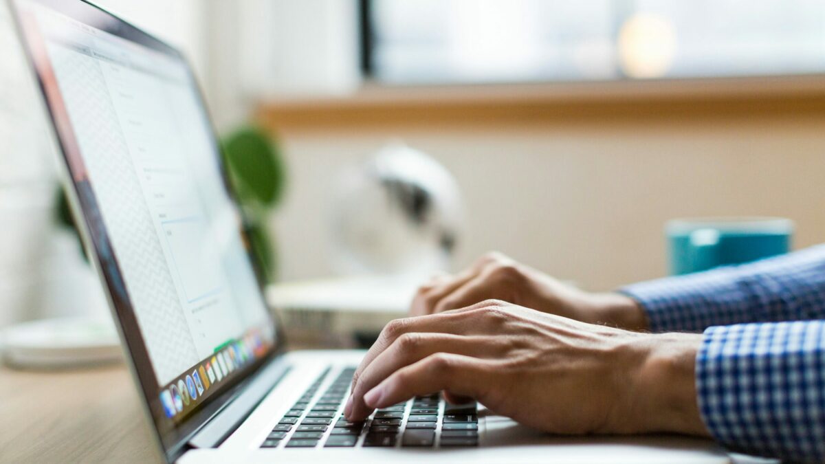 person typing on silver Macbook